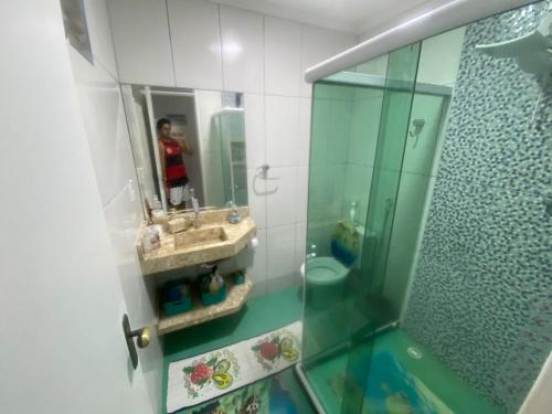 una donna che scatta una foto di un bagno con specchio di Casa Arraial ad Arraial do Cabo