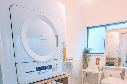 a microwave in a bathroom with a sink at カモゲストハウス ペット不可 in Tsuruoka
