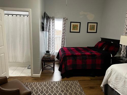 1 dormitorio con 1 cama con manta roja y ventana en Country Club, en Wadley