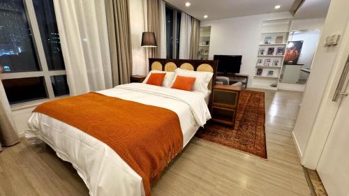 a bedroom with a large bed with an orange blanket at River House Near The Peoples Square And The Bund in Shanghai