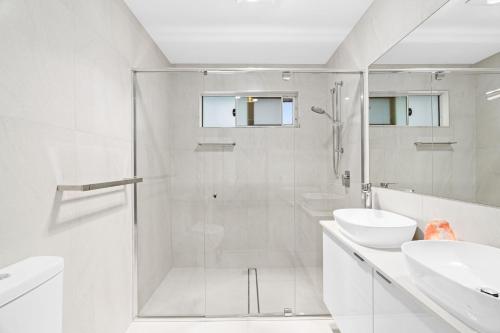 baño blanco con ducha y lavamanos en 24 Allura Circuit - Central Coolum Beach House, en Coolum Beach