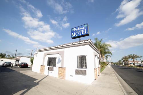 un pequeño edificio blanco con un cartel encima en Palms Motel, en Pico Rivera