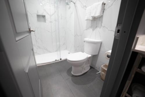 Un baño blanco con ducha y WC. en Palms Motel, en Pico Rivera