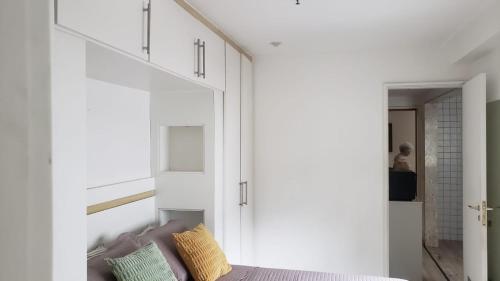 una camera da letto con pareti bianche e un letto con cuscini gialli di Apartamento Frente Lagoa - RJ a Rio de Janeiro