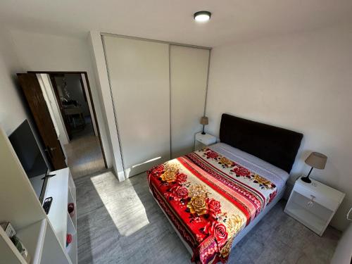 a bedroom with a bed with a colorful blanket at Villa Gesell- Av.27 e/100 y 101 in Villa Gesell