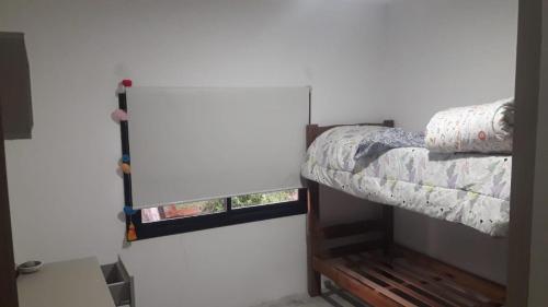 a small bedroom with a bunk bed with a window at Villa Gesell- Av.27 e/100 y 101 in Villa Gesell