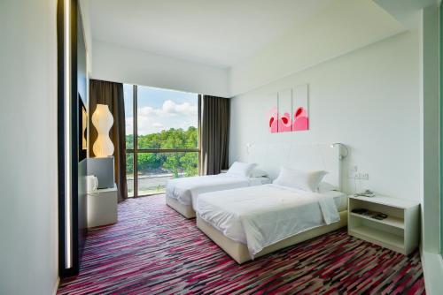 a hotel room with two beds and a large window at Pegasus Hotel Shah Alam in Shah Alam