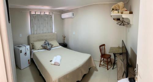 a small bedroom with a bed and a table at Apartamento 01 Le Sorelle in Rosário do Sul