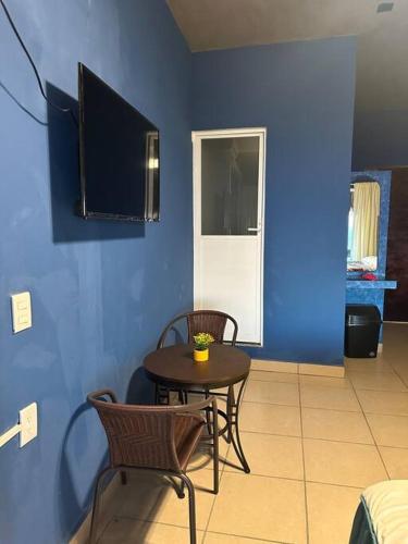 a room with a table and chairs and a blue wall at Brisa Del Mar #1 in Puerto Escondido