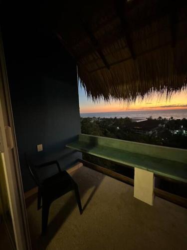 a room with a bench and a view of the ocean at Brisa Del Mar #1 in Puerto Escondido
