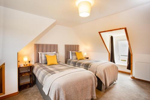 a bedroom with two beds and a large mirror at Mike's 3-bedroom Countryside Cottage in Alness