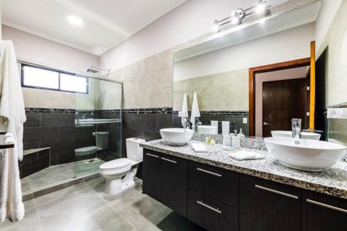 a bathroom with two sinks and a toilet and a shower at Casa Emma - Oasis Playa Potrero in Playa Flamingo
