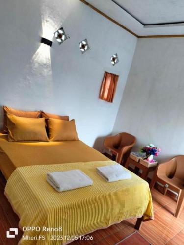 a bedroom with a bed with two towels on it at Anadas Garden & Glamping in Pagaralam