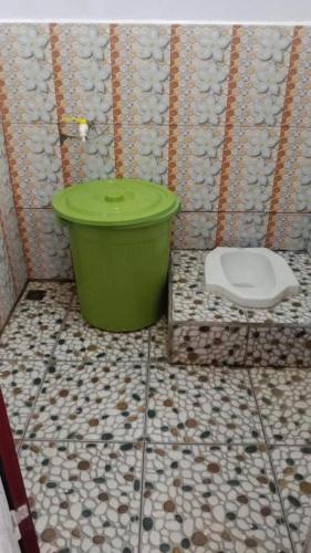 a bathroom with a green tub and a toilet at Anadas Garden & Glamping in Pagaralam