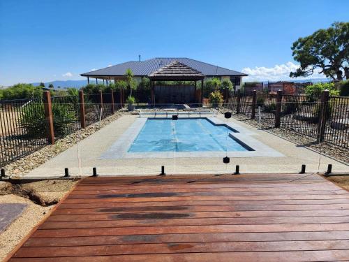 a swimming pool with a gazebo and a house at Dan's Rise in Mansfield