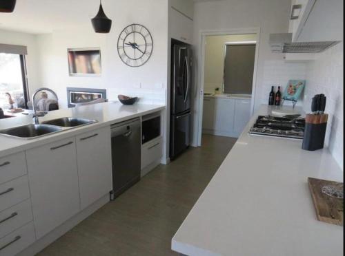a white kitchen with a sink and a refrigerator at Dan's Rise in Mansfield