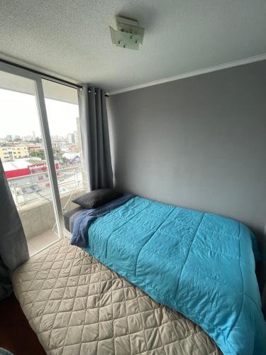 a bed in a room with a window at Departamento pleno centro de Viña del Mar in Viña del Mar