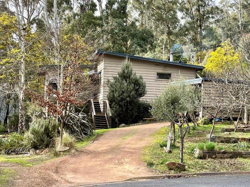 a house with a dirt road in front of it at Christensen Lodge in Merrijig