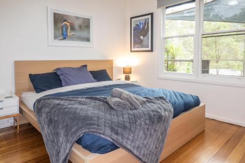 Un dormitorio con una cama con una manta encima. en Christensen Lodge, en Merrijig