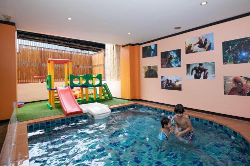 dos niños jugando en una piscina cubierta en Hotel Sole, en Patong Beach