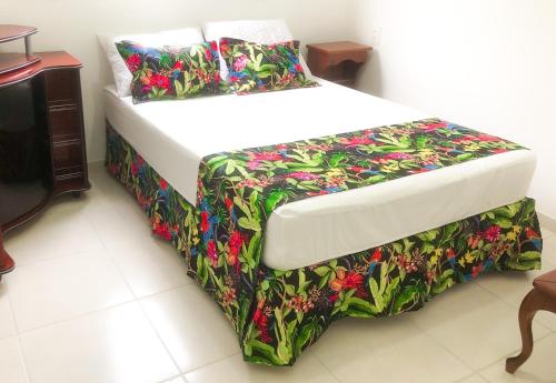 una camera da letto con un letto con copriletto floreale di Apartamento de 3 quartos em Jurerê a Florianópolis