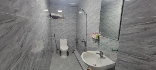 uma casa de banho com um lavatório, um WC e um espelho. em Motel Xuân Hòa em Bắc Ninh