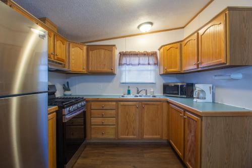 a kitchen with wooden cabinets and a stainless steel refrigerator at Stay in Ohiopyle in the center of it all, Ohiopyle, PA in Farmington