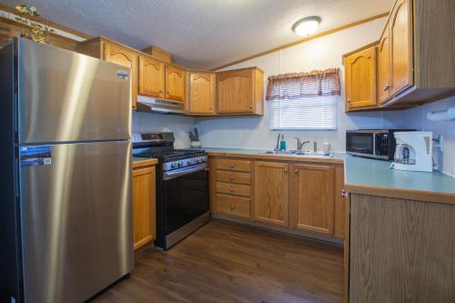 a kitchen with wooden cabinets and a stainless steel refrigerator at Stay in Ohiopyle in the center of it all, Ohiopyle, PA in Farmington