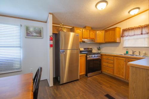 a kitchen with a stainless steel refrigerator and wooden cabinets at Stay in Ohiopyle in the center of it all, Ohiopyle, PA in Ohiopyle
