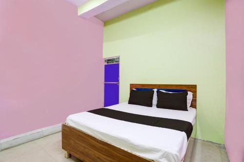 a bedroom with a bed with colorful walls at OYO Flagship Up13 Hotel in Jhājhar