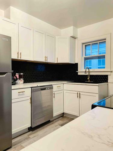 a kitchen with white cabinets and a stainless steel refrigerator at Centrally Located EVV Apartments in Evansville