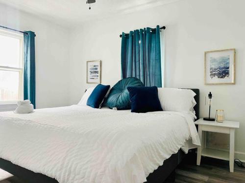 a bedroom with a large bed with blue curtains at Centrally Located EVV Apartments in Evansville