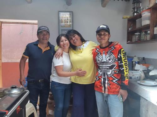 a group of people posing for a picture in a kitchen at EColodge Ccatan in Urubamba