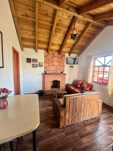 ein Wohnzimmer mit einem Sofa und einem Kamin in der Unterkunft Cabañas el Corral del Rayo Huasca in Huasca de Ocampo