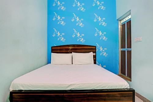 um quarto com uma cama com uma parede azul em OYO Hotel The Paradise Inn em Jhajjar