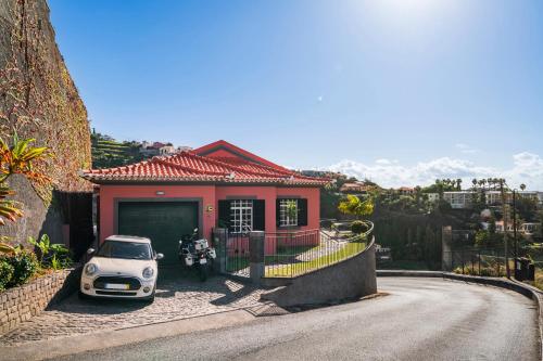 ein kleines Haus mit einem davor geparkt in der Unterkunft Casa Coelho in Ponta do Sol