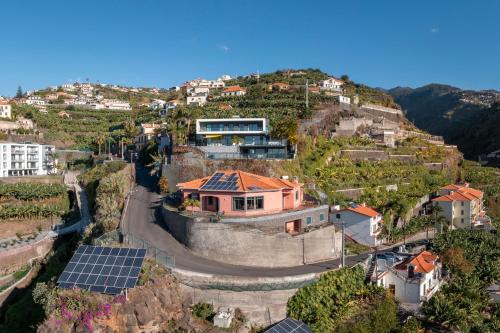 uma casa no topo de uma colina com painéis solares em Casa Coelho em Ponta do Sol