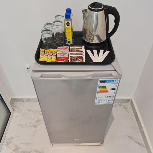 a refrigerator with a tea kettle on top of it at White Garden Hotel in Maputo