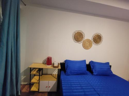 a bedroom with a bed with blue pillows and a table at Top View Kohrong in Koh Rong