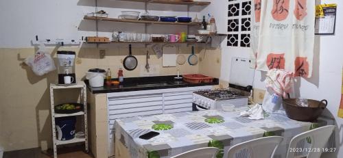 cocina pequeña con mesa y fogones en Casa prática e completa próxima de tudo en Ubatuba