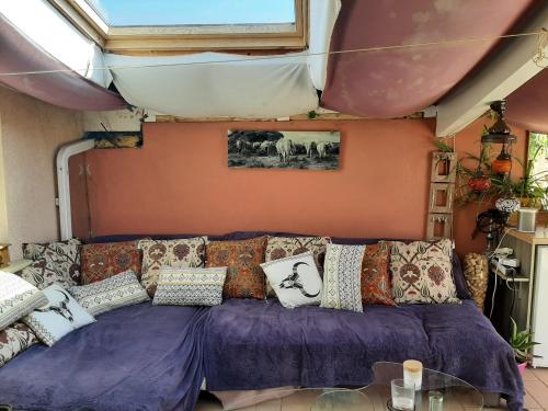 uma sala de estar com um sofá roxo com almofadas em Maison Tarnos, 4 pièces, 6 personnes - FR-1-239-779 em Tarnos