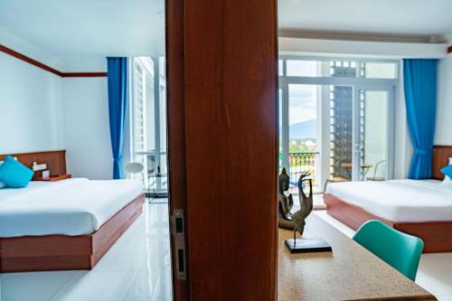 a hotel room with two beds and a balcony at Kampot View Boutique in Kampot