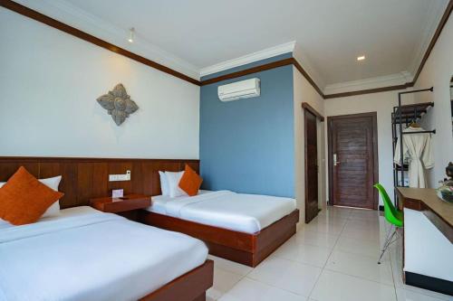 a bedroom with two beds and a blue wall at Kampot View Boutique in Kampot