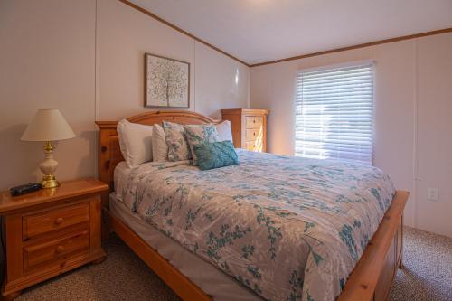 a bedroom with a bed and a lamp and a window at Stay In Ohiopyle near the GAP Trail - Ohiopyle, PA in Ohiopyle