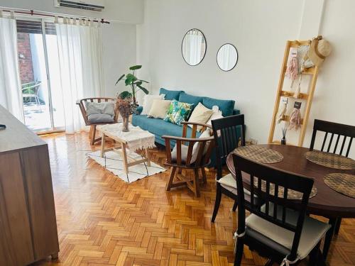 sala de estar con sofá azul y mesa en Departamento 3 ambientes con patio, terraza y parrila en Buenos Aires