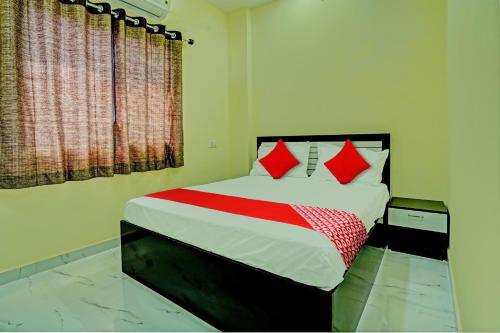 a bedroom with a large bed with red pillows at OYO Flagship Hotel Bliss Inn in Rāipur