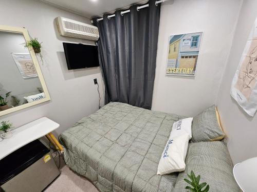 a small bedroom with a bed and a sink at Seoul Stay in Seoul