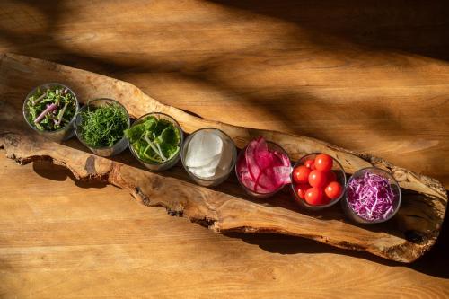 four different types of vegetables in bowls on a wooden table at Hotel Anteroom Kyoto in Kyoto