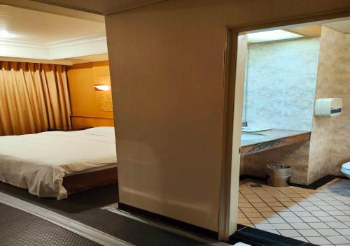 a hotel room with a bed and a window at Champion Hotel in Taipei