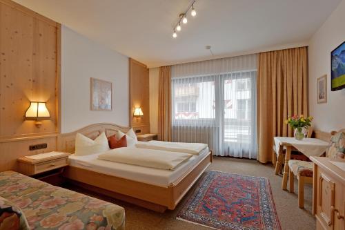 En eller flere senge i et værelse på Hotel Garni Jennewein